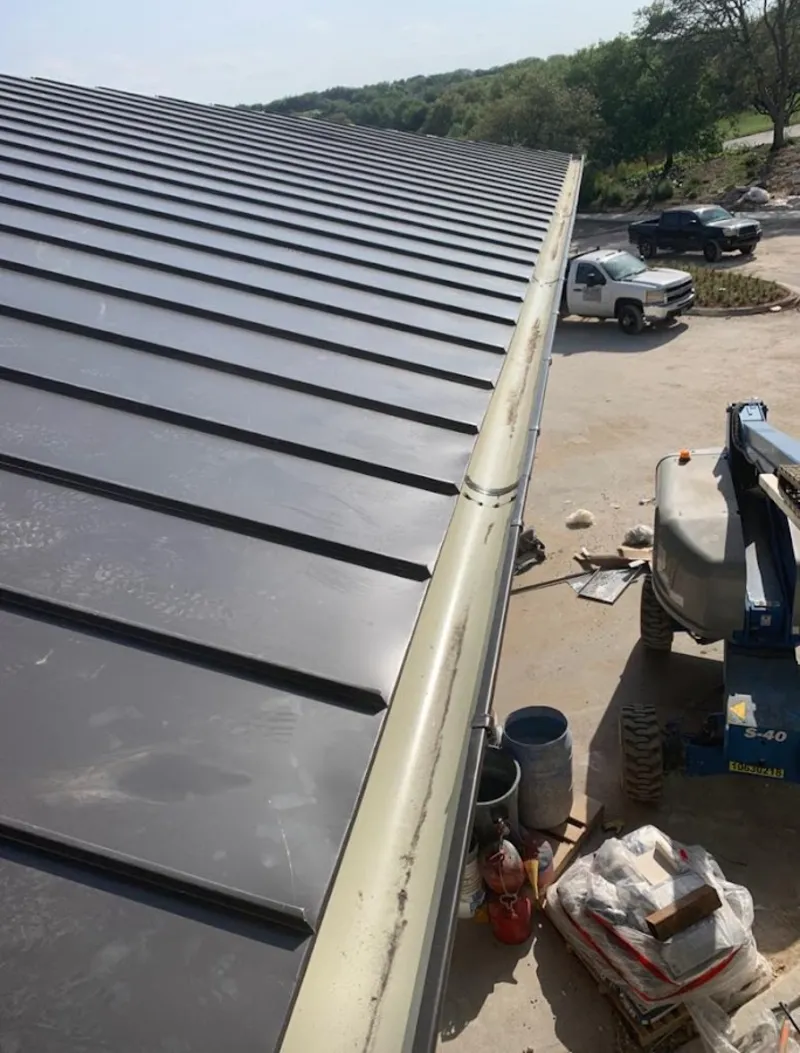 Standing seam panel and gutter detail on a metal roofing jobsite in Clover